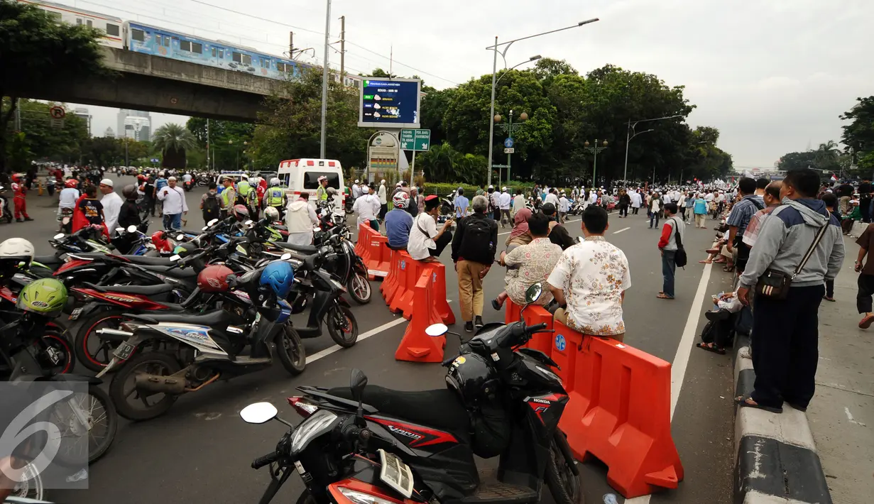 Sejumlah motor terparkir akibat penutupan Jalan Medan Merdeka Timur saat ribuan massa ormas melakukan unjuk rasa di Bareskrim Polri, Gedung KKP Jakarta, Jumat (14/10). (Liputan6.com/Helmi Fithriansyah)