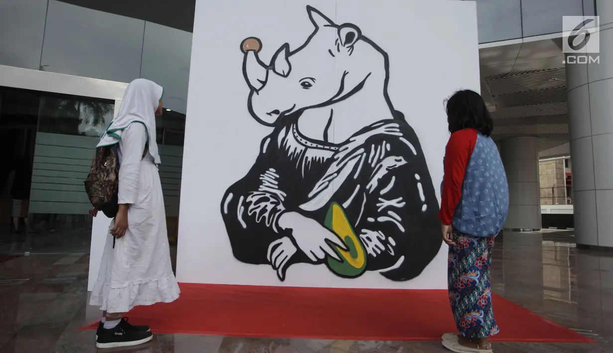 Dua anak kecil melihat-lihat karya dalam pameran seni badak Sumatera di Perpustakaan Nasional Indonesia, Jakarta Pusat, Jumat (19/1). Karya para seniman tersebut akan didonasikan kepada Konsorsium Konservasi Badak Sumatera. (Liputan6.com/Arya Manggala)