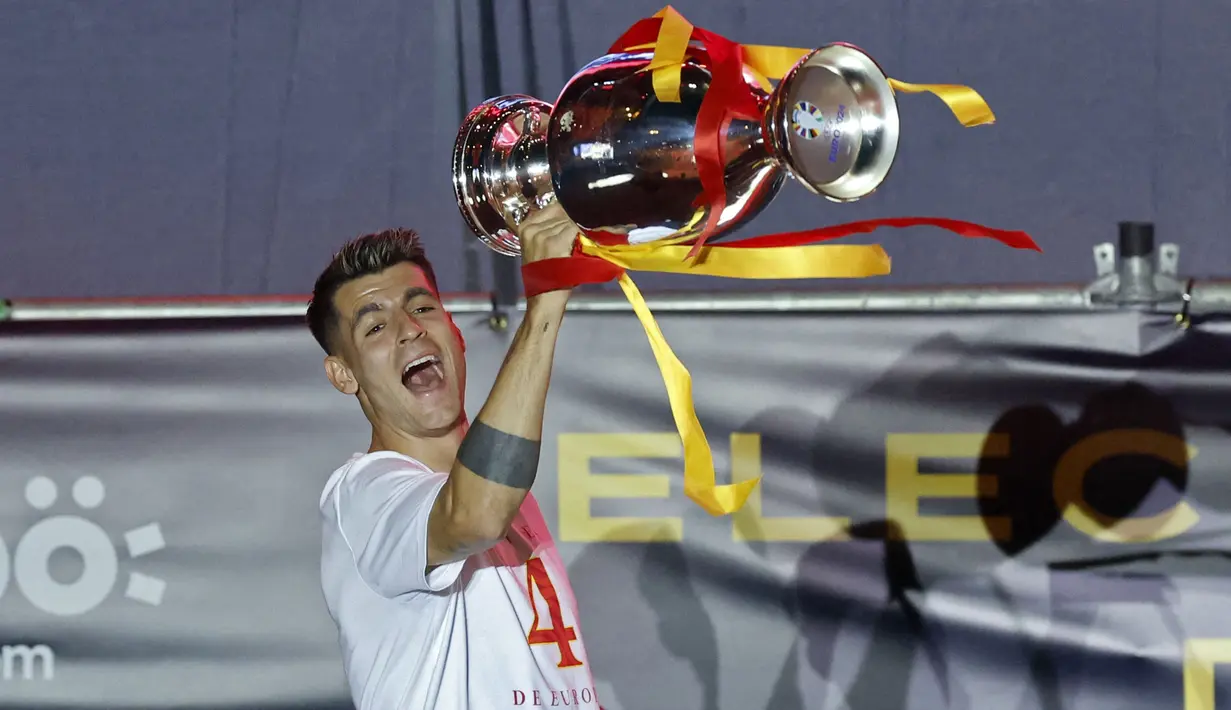 <p>Kapten timnas Spanyol, Alvaro Morata merayakan kemenangan dengan trofi saat parade kemenangan Euro 2024 di Madrid, Spanyol, Senin (15/07/2024) waktu setempat. (AFP/Oscar Del Pozo)</p>