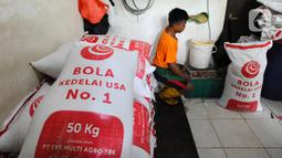 Pekerja menimbang kedelai untuk pembuatan tahu di Pabrik Tahu Krukut, Depok, Jawa Barat, Senin (31/10/2022). Kenaikan harga kedelai yang sekarang mencapai Rp 14 ribu/kg menyebabkan produksi tahu menurun dari 2,5 - 3 kwintal kedelai/hari kini hanya 2 kwintal/hari, sementara jumlah tenaga kerja pun harus dikurangi dari enam menjadi hanya lima orang. (merdeka.com/Arie Basuki)