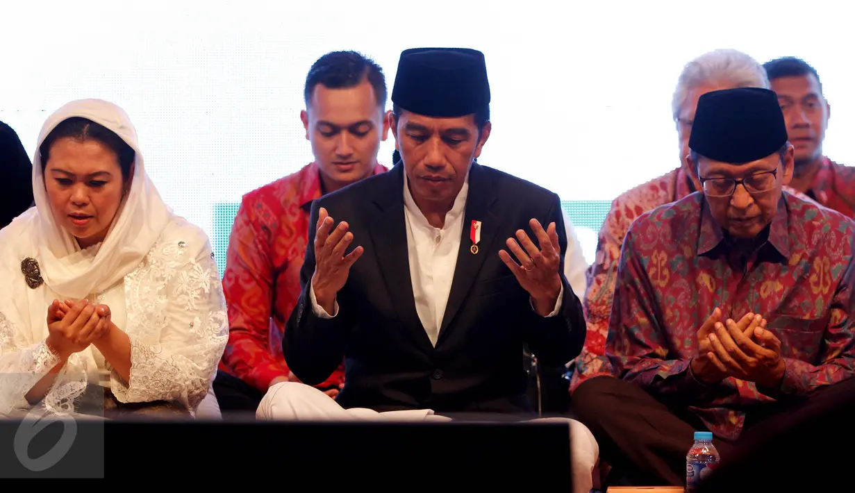 Presiden Joko Widodo (tengah), Yenny Wahid dan Mantan Wapres Boediono ketika berdoa pada peringatan Haul Gus Dur ke 7 dan Peringatan Maulid Nabi Muhammad SAW di Ciganjur, Jakarta, Sabtu (23/12). (Liputan6.com/Gempur M Surya