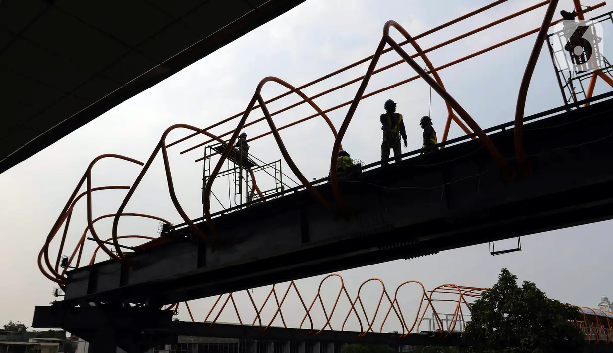 Pekerja menyelesaikan pembangunan jembatan penyeberangan orang (skywalk) di kawasan Kebayoran Lama, Jakarta, Rabu (2/11/2022). Pengerjaan skywalk sepanjang 500 meter dengan desain cahaya artistik dan dilengkapi fasilitas lift nantinya mengintegrasikan Stasiun Kebayoran dengan Halte Transjakarta Koridor 8 dan Koridor 13. (Liputan6.com/Herman Zakharia)