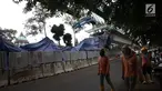 Pekerja melintas dekat kontruksi beton proyek light rapid transit ( LRT)  yang roboh di Kayu Putih, Jakarta Timur, Senin (22/1). Akibat robohnya konstruksi beton proyek LRT ini setidaknya lima orang yang mengalami luka-luka. (Liputan6.com/Arya Manggala)