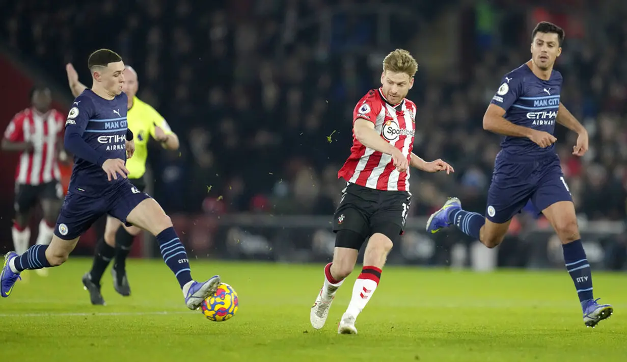 Pemain Manchester City Phil Foden (kiri) memblok tendangan dari pemain Southampton Stuart Armstrong (tengah) pada pertandingan sepak bola Liga Inggris di Stadion St Mary, Southampton, Inggris, 22 Januari 2022. Manchester City bermain imbang 1-1. (AP Photo/Kirsty Wigglesworth)