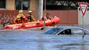 Pekerja darurat melihat mobil yang terendam banjir di pinggiran Kota Melbourne, Maribyrnong, Australia, Jumat (14/10/2022). State Emergency Service atau SES melaporkan ada satu orang hilang akibat dampak meluapnya Sungai Loddon. Namun, sejauh ini belum ada kabar korban jiwa. (William WEST/AFP)