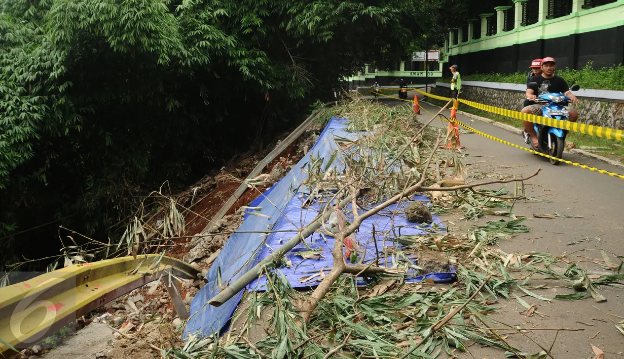 Warga melintas di jalan Gardu, Jagakarsa yang mengalami longsor pada Jumat (12/2) lalu, Jakarta, Sabtu (13/2/2016). Longsor terjadi akibat guyuran hujan deras dan tidak ada korban dalam peristiwa ini. (Liputan6.com/Helmi Fithriansyah)