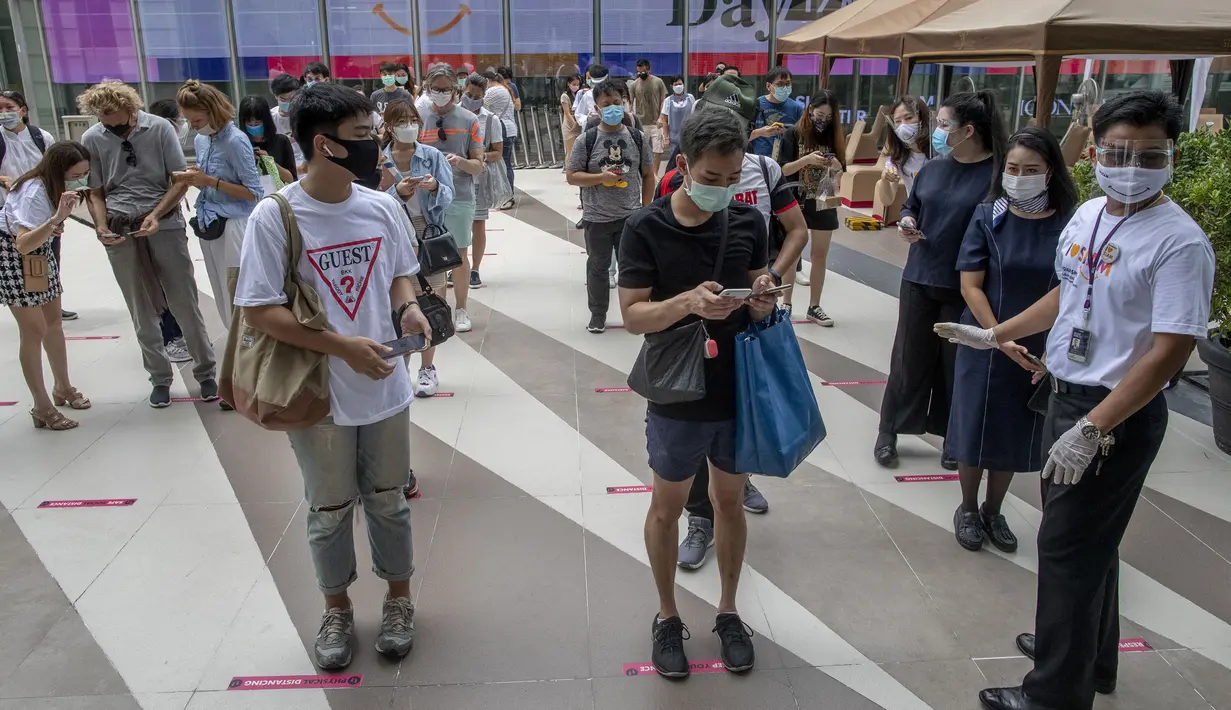Pengunjung menjaga jarak fisik saat akan masuk mal mewah Siam Paragon di Bangkok, Thailand, Minggu (17/5/2020). Thailand mengizinkan toko serba ada, pusat perbelanjaan, dan bisnis lain kembali dibuka untuk menghidupkan kembali ekonomi yang rusak akibat pandemi COVID-19. (AP Photo/Gemunu Amarasinghe)