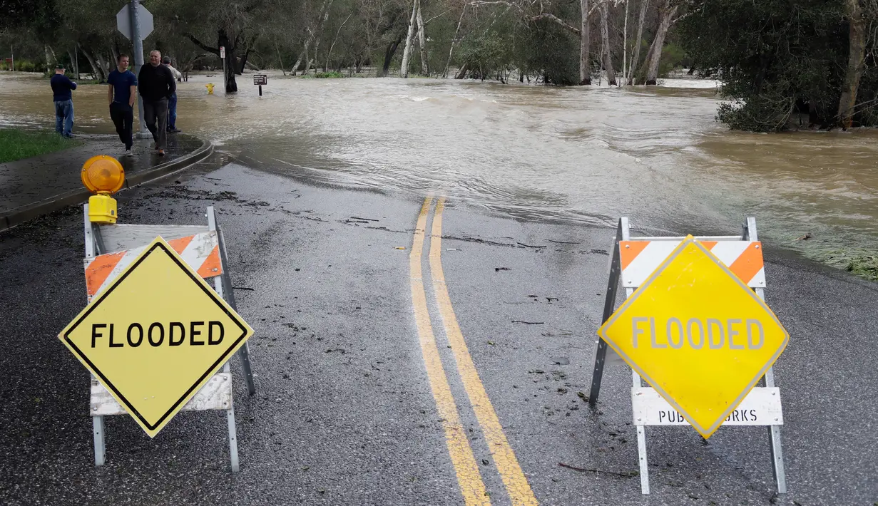 Papan pemberitahuan meluapnya Sungai Coyote Creek terpasang di Morgan Hill, California, Selasa (21/2). Sungai Coyote Creek yang tidak mampu menampung debit air setelah hujan lebat mengakibatkan California terendam banjir. (AP Photo/Marcio Jose Sanchez)