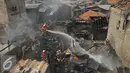 Warga membantu petugas memadamkan api saat kebakaran di Jalan Kramat Pulo Dalam RT 03 RW 08, Senen, Jakarta, Selasa (3/11/2015). Sekitar 10 rumah hangus akibat kebakaran yang terjadi. (Liputan6.com/Gempur M Surya)