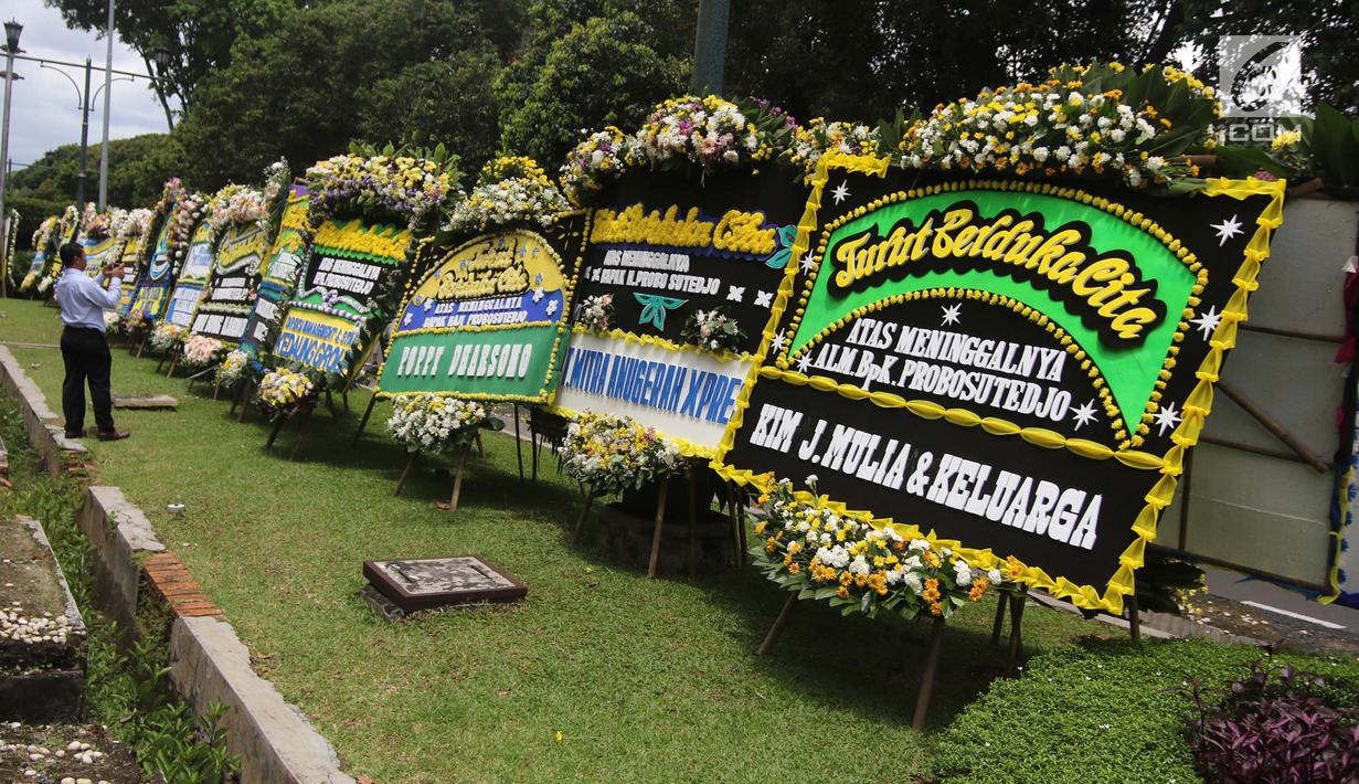 Warga mengambil gambar karangan bunga ucapan duka cita untuk Probosutedjo yang memenuhi Jalan Diponegoro, Jakarta, Senin (26/3). Probosutedjo meninggal dunia pada usia 87 tahun. (Liputan6.com/Arya Manggala)