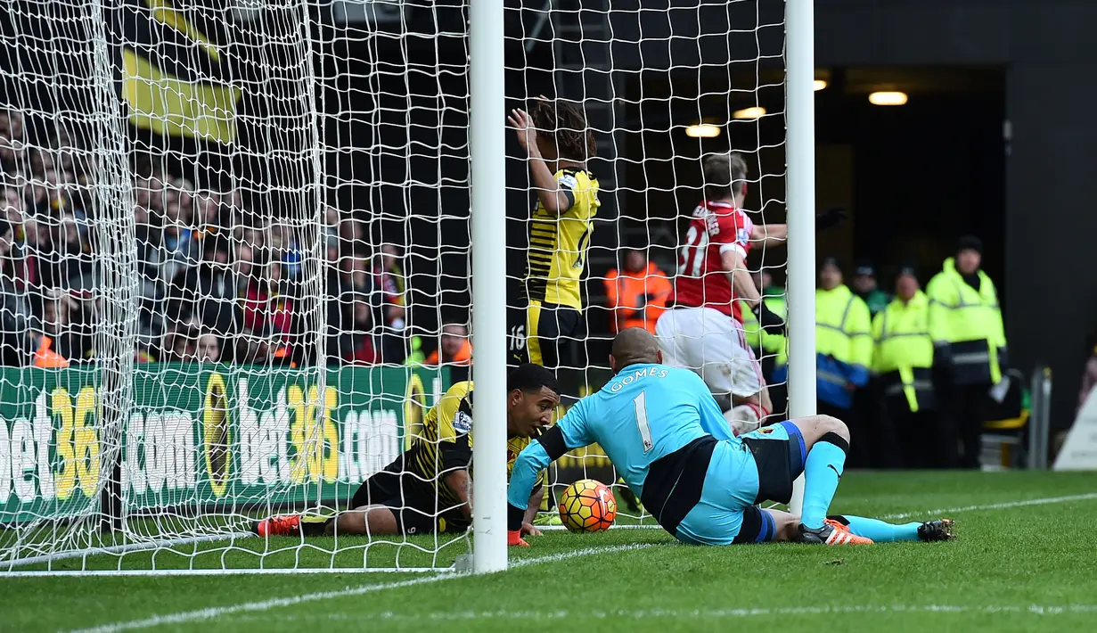 Striker Watford, Troy Deeney, terjatuh ke dalam gawangnya bersama bola yang ditendang pemain MU, Bastian Schweinsteiger, dalam lanjutan Liga Inggris di Stadion Icarage Road, Watford, Sabtu (21/11/2015). (AFP Photo/Ben Stansall)