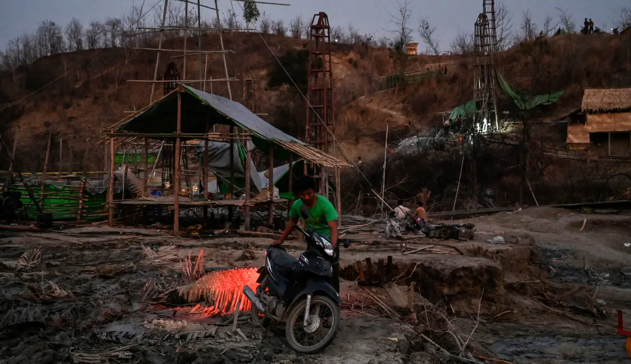 Pekerja menyiapkan motornya di lokasi pengeboran sumur minyak ilegal di Minhla, Myanmar, 10 Maret 2019. Para pekerja tinggal dalam gubuk-gubuk yang berada tepat di sebelah sumur minyak ilegal. (Ye Aung THU/AFP)