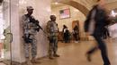 Pasukan Garda Nasional bersenjata laras panjang berjaga di terminal Grand Central, New York City, pasca teror bom pipa, Senin (11/12). Empat orang, termasuk pelaku dikabarkan mengalami luka-luka akibat teror bom tersebut. (JOHN MOORE / GETTY IMAGES / AFP)