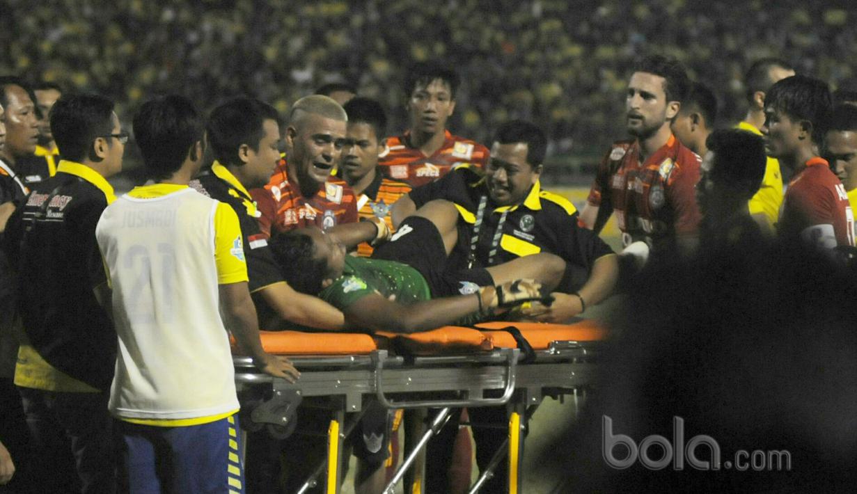 Christian Gonzales ikut mengangkat kiper Persegres, Aji Saka yang terjatuh akibat menghantam tiang gawang sebelah kanan saat melawan Arema FC pada Liga 1 2017 di Gresik, (12/7/2017). (Bola.com/Iwan Setiawan). 