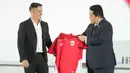 Ketua Persatuan Sepak Bola Seluruh Indonesia (PSSI), Erick Thohir (kanan) menyerahkan jersey tim kepada pelatih kepala tim nasional Indonesia yang baru ditunjuk, John Herdman, saat konferensi pers di Jakarta, Selasa 13 Januari 2026. Persatuan Sepak Bola Seluruh Indonesia (PSSI) resmi memperkenalkan John Herdman sebagai pelatih baru Timnas Indonesia. (AP Photo/Achmad Ibrahim)