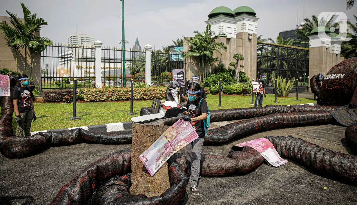 Aktivis Greenpeace menggelar aksi di depan Gedung DPR RI, Jakarta, Selasa (5/10/2021). Dalam aksinya, mereka membawa gurita raksasa sebagai simbol oligarki serta menyerukan kepada pemerintah agar serius mengatasi pandemi dan memberantas korupsi energi. (Liputan6.com/Faizal Fanani)