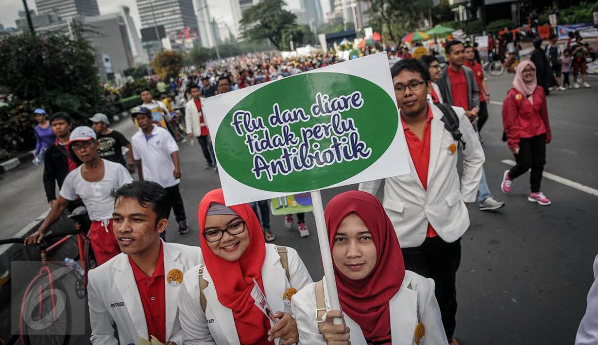 Peserta dari ISMAFARSI memperlihatkan poster saat melakukan longmarch memperingati Hari Apoteker Sedunia di kawasan Car Free Day, Jakarta, Minggu (25/9). Mereka mengajak masyarakat cerdas menggunakan obat, termasuk DaGuSiBu. (Liputan6.com/Faizal Fanani)