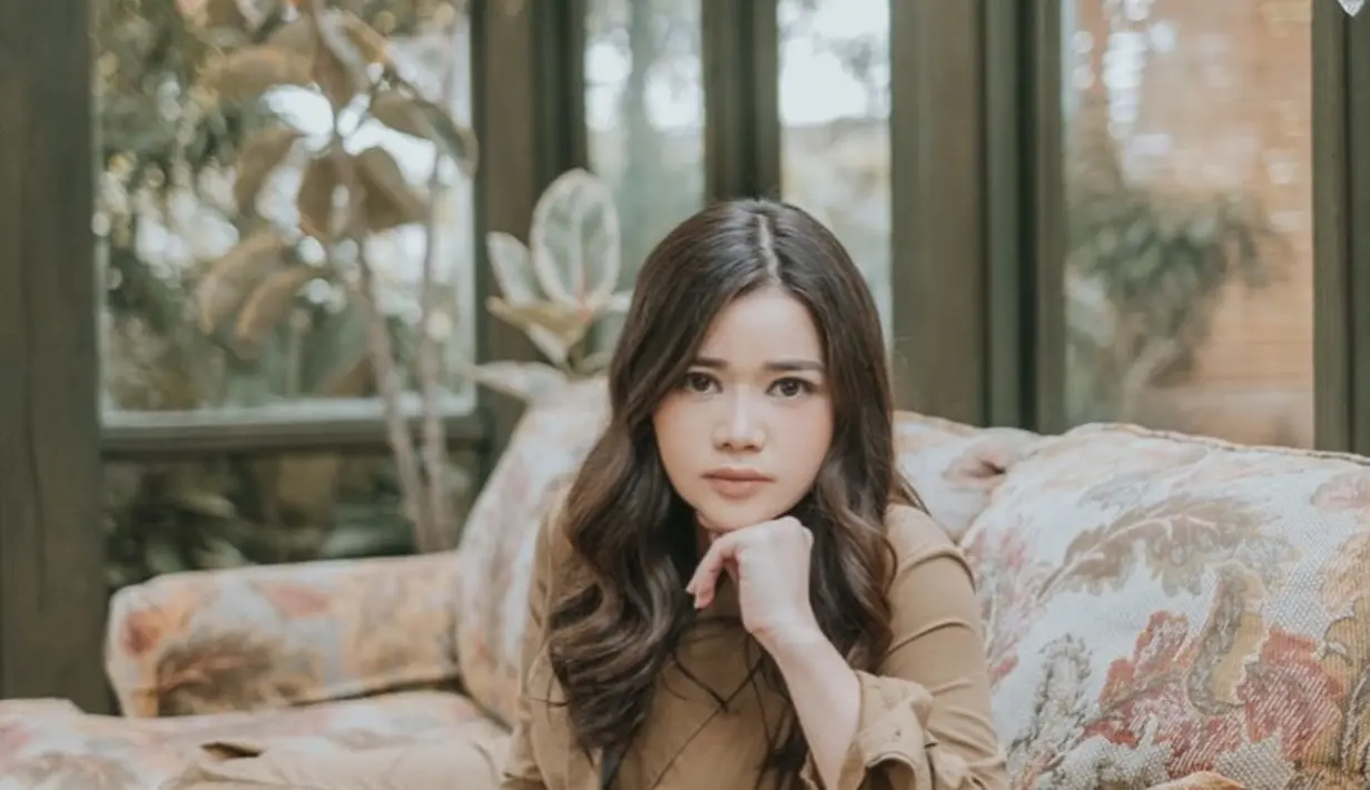 Gaya cantik Olivia Allan mengenakan simple dress berwarna cokelat. Dress ini memiliki detail lengan panjang dan high slit sebagai pemanis penampilannya secara keseluruhan. Foto: Instagram.