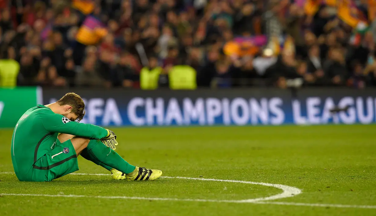 Kiper PSG, Kevin Trapp terduduk lesu usai dikalahkan Barcelona pada leg kedua babak 16 besar Liga Champions di stadion Camp Nou, Spanyol (9/3). Barcelona menang 6-1 (agregat 6-5). (AFP PHOTO / Lluis GENE)
