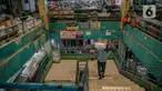 Seorang pria memanggul barang di Pasar Pondok Labu, Jakarta, Rabu (10/2/2021). Satu pedagang dinyatakan positif Covid-19, meski begitu pengelola Pasar Pondok Labu tetap melanjutkan operasional pasar sambil melakukan penyemprotan cairan disinfektan selama tiga hari. (Liputan6.com/Faizal Fanani)