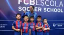 Ronaldinho mengakhiri sesi kunjungannya dengan foto bersama anak-anak peserta akademi Barcelona. (AFP/Handout)