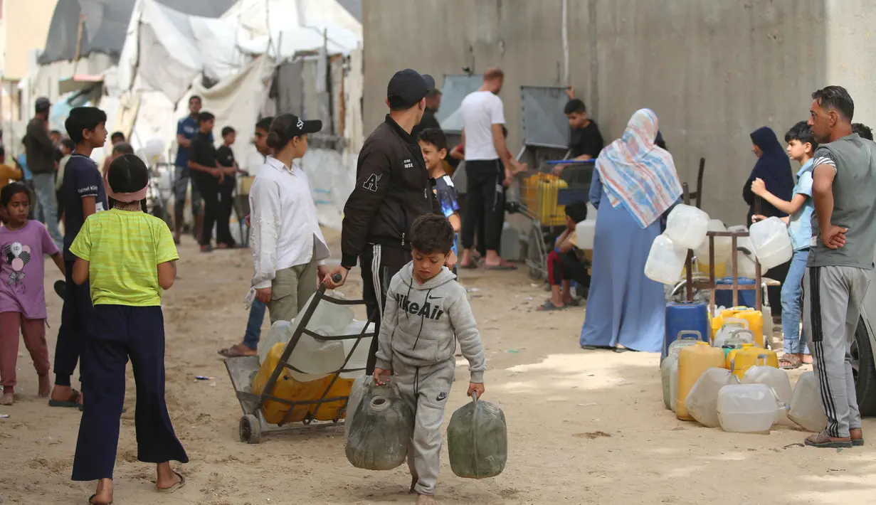 Warga Palestina yang mengungsi mengumpulkan air minum untuk dibawa kembali ke tempat penampungan mereka setelah rumah mereka hancur akibat bombardir Israel, di kamp pengungsi Bureij, Jalur Gaza Tengah pada Senin 18 Mei 2026. (Eyad Baba/AFP)