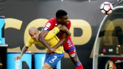 Pemain Brasil Dani Alves (kir) berebut bola dengan pemain Haiti, Kervens Belfort pada lanjutan  Copa America Centenario 2016 di Orlando, Florida, AS, (9/6/2016) WIB. (AFP/Gregg Newton)