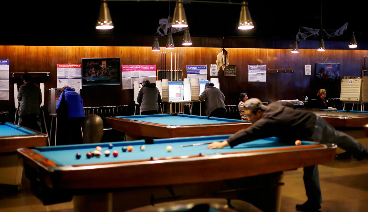 Pemilih memberikan suaranya di sebuah arena billiard yang dijadikan lokasi tempat pemungutan suara (TPS) pemilihan presiden Amerika Serikat (Pilpres AS) di Chicago, Illinois, Selasa (8/11). (REUTERS/Jim Young)