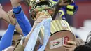 Pemain Napoli Lorenzo Insigne memegang trofi setelah timnya mengalahkan Juventus pada final Coppa Italia di Olympic Stadium, Roma, Italia, Rabu (17/6/2020). Napoli menjadi juara Coppa Italia 2019-2020 setelah mengalahkan Juventus lewat drama adu penalti. (Filippo MONTEFORTE/AFP)