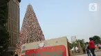 Warga melihat pohon Natal dari miniatur ondel-ondel yang terbuat dari botol minuman bekas di Food Court Thamrin 10, Jakarta, Sabtu (21/12/2019). Sekitar 8.000 botol air mineral bekas dihias dan dirangkai menyerupai Pohon Natal yang bisa disaksikan oleh masyarakat. (Liputan6.com/Helmi Fithriansyah)