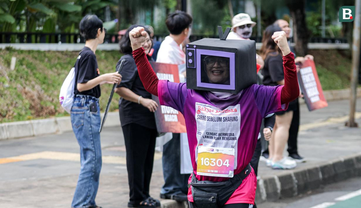 Seorang peserta lari menggunakan kostum berbentuk televisi dalam ajang Run for Journalism 2025 yang berlangsung di Unika Atma Jaya, Jakarta, Minggu (16/11/2025). (Bola.com/Bagaskara Lazuardi)