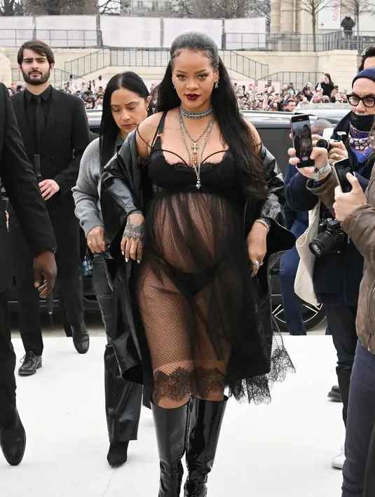 <p>Rihanna menjadi tamu VIP show Dior. Dengan baby-bumpnya, Rihanna tampil luar biasa dengan busana serba hitam rancangan Dior. Foto: Vogue.</p>