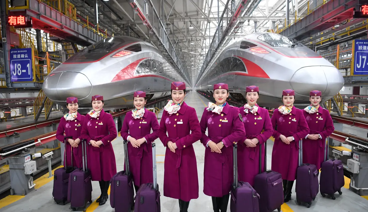 Sejumlah awak pengoperasian pertama kereta peluru Fuxing CR400AF berpose di depan kereta di stasiun pemeliharaan depo gerbong kereta di Kota Chongqing, China barat (23/12/2020). Kereta itu akan mulai beroperasi pada Kamis (24/12). (Xinhua/Tang Yi)