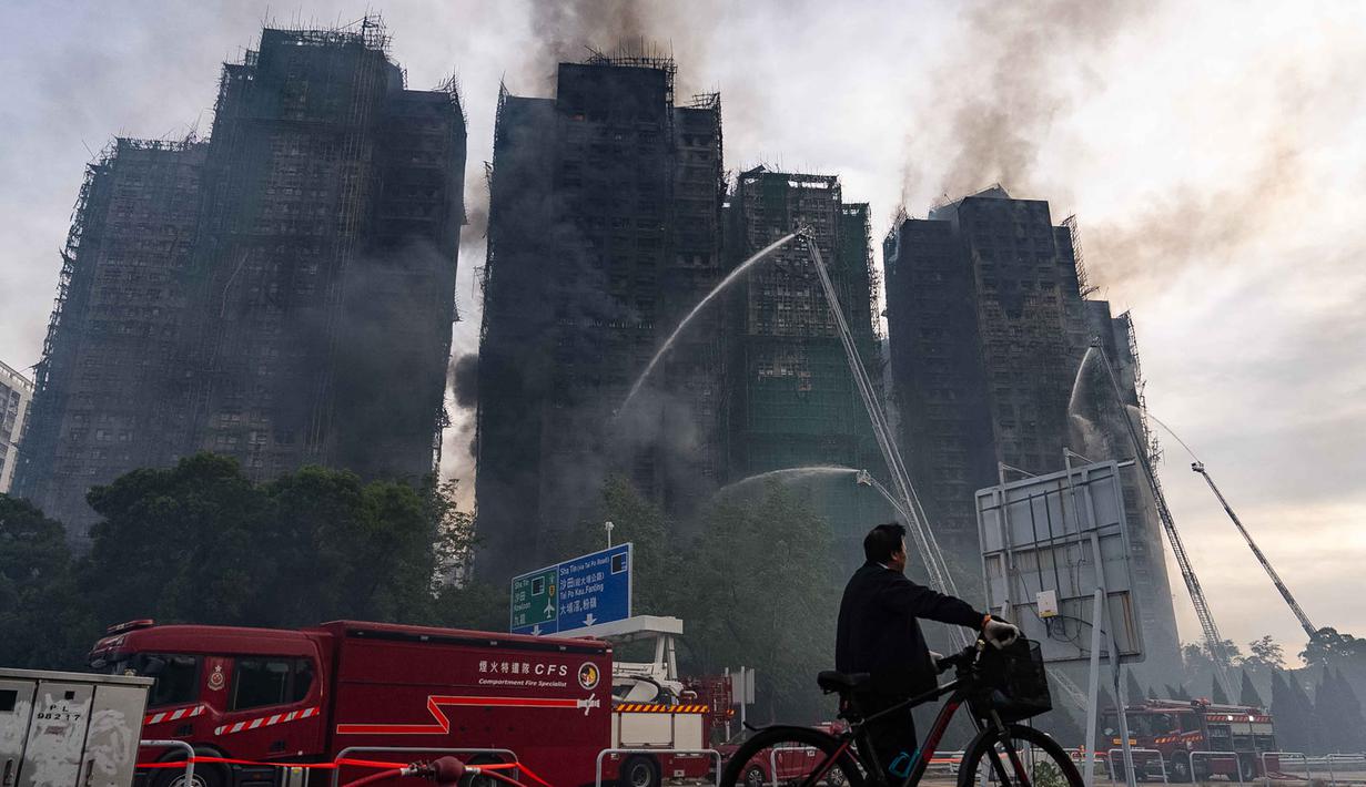 Petugas pemadam kebakaran berupaya memadamkan kebakaran yang terjadi di Wang Fuk Court, sebuah kompleks perumahan di distrik Tai Po, Wilayah Baru Hong Kong, Kamis 27 November 2025. Kebakaran dahsyat melanda Hong Kong. Setidaknya delapan gedung dan hampir 2.000 apartemen terbakar. (AP Photo/Chan Long Hei)