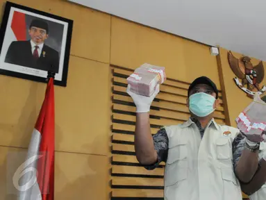 Petugas menunjukkan barang bukti hasil OTT terkait dugaan suap pengurusan perkara Saipul Jamil di KPK, Jakarta, Kamis (16/6). Kakak Saipul Jamil diketahui melakukan suap kepada Panitera PN Jakarta Utara dengan uang Rp 250 juta. (Liputan6.com/Helmi Afandi)