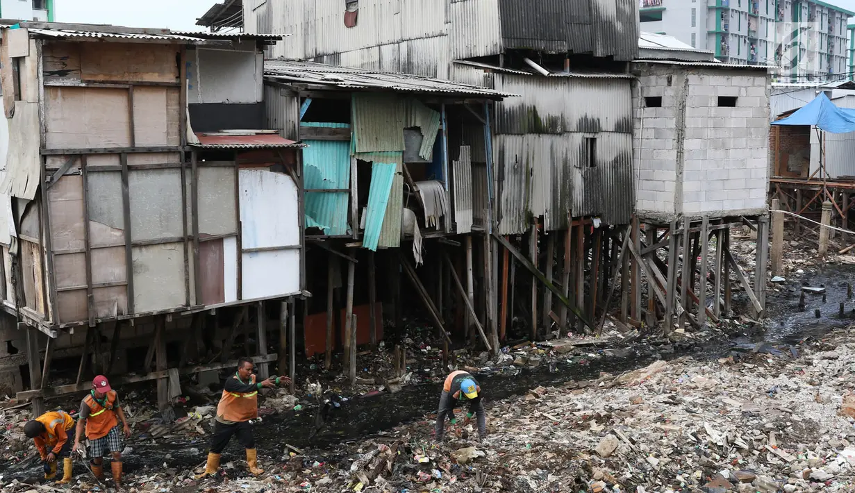 Petugas membersihkan sampah yang memenuhi aliran Kali Gendong di kawasan Penjaringan, Jakarta, Senin (3/12). Penumpukan sampah akibat tidak tersedianya tempat pembuangan. (Liputan6.com/Immanuel Antonius)