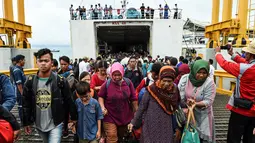 Para pengungsi turun dari kapal ferry usai dievakuasi dari Pulau Sebesi, di Pelabuhan Bakauheni, Lampung, Rabu (26/12). Ribuan pengungsi tsunami dari Pula Sebesi terpaksa dievakuasi menggunakan kapal ferry. (AFP Photo/Mohd Rasfan)