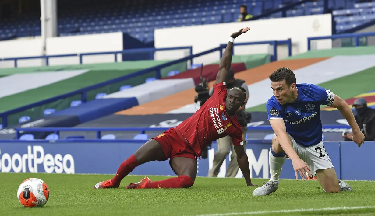 PemainEverton Seamus Coleman (kanan) berebut bola dengan pemain Liverpool Sadio Mane pada lanjutan Liga Primer Inggris di Goodison Park, Liverpool, Inggris, Minggu (21/6/2020). Pertandingan berakhir dengan skor 0-0. (Peter Powell/Pool via AP)