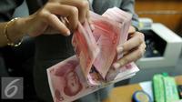 Petugas menghitung uang pecahan 100 Yuan, Jakarta, Kamis (13/8/2015). Biang kerok keterpurukan kurs rupiah dan sejumlah mata uang negara lain adalah kebijakan China yang sengaja melemahkan (devaluasi) mata uang Yuan. (Liputan6.com/Johan Tallo)