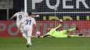 Pemain Real Madrid Karim Benzema (kiri) mencetak gol lewat tendangan penalti ke gawang Cadiz yang dijaga kiper Jeremias Ledesma pada pertandingan La Liga Spanyol di Stadion Ramon Carranza, Cadiz, Spanyol, Rabu  (21/4/2021). Real Madrid menang 3-0. (AP Photo/Jose Breton)