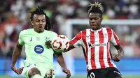 Pemain belakang Barcelona asal Prancis Jules Kounde berebut bola dengan pemain depan Athletic Bilbao Nico Williams pada pertandingan semifinal Piala Super Spanyol di King Abdullah Sport City, Jeddah, 8 Januari 2025. (FADEL SENNA / AFP)