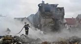 Petugas pemadam kebakaran memadamkan api di rumah-rumah pribadi yang rusak setelah serangan Rusia di wilayah Kyiv pada 25 Mei 2025, di tengah invasi Rusia di Ukraina. (Sergei SUPINSKY/AFP)