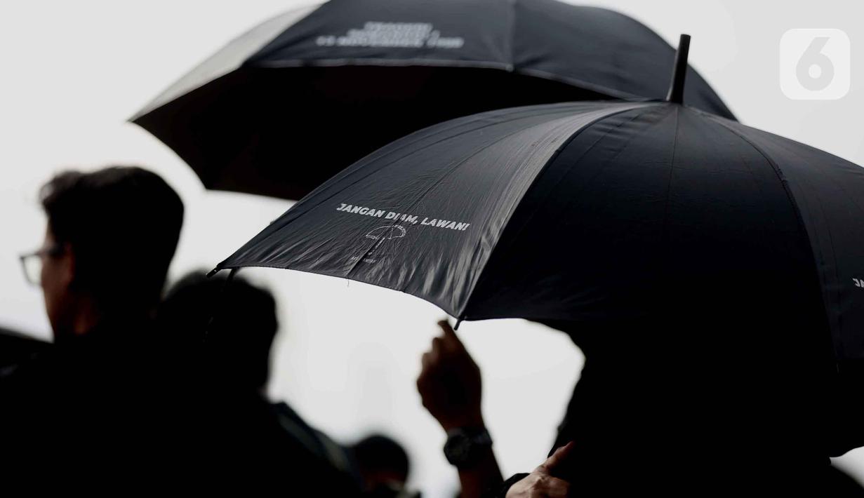 Para peserta aksi yang identik dengan payung hitam ini konsisten berdiri di depan Istana Merdeka setiap hari Kamis untuk menuntut keadilan dan penuntasan kasus-kasus kemanusiaan masa lalu. Tampak dalam foto, aktivis Jaringan Solidaritas Korban untuk Keadilan saat mengikuti peringatan 19 tahun Aksi Kamisan di Jalan Medan Merdeka Utara atau di seberang Istana Merdeka, Jakarta, 15 Januari 2026. (Liputan6.com/Helmi Fithriansyah)