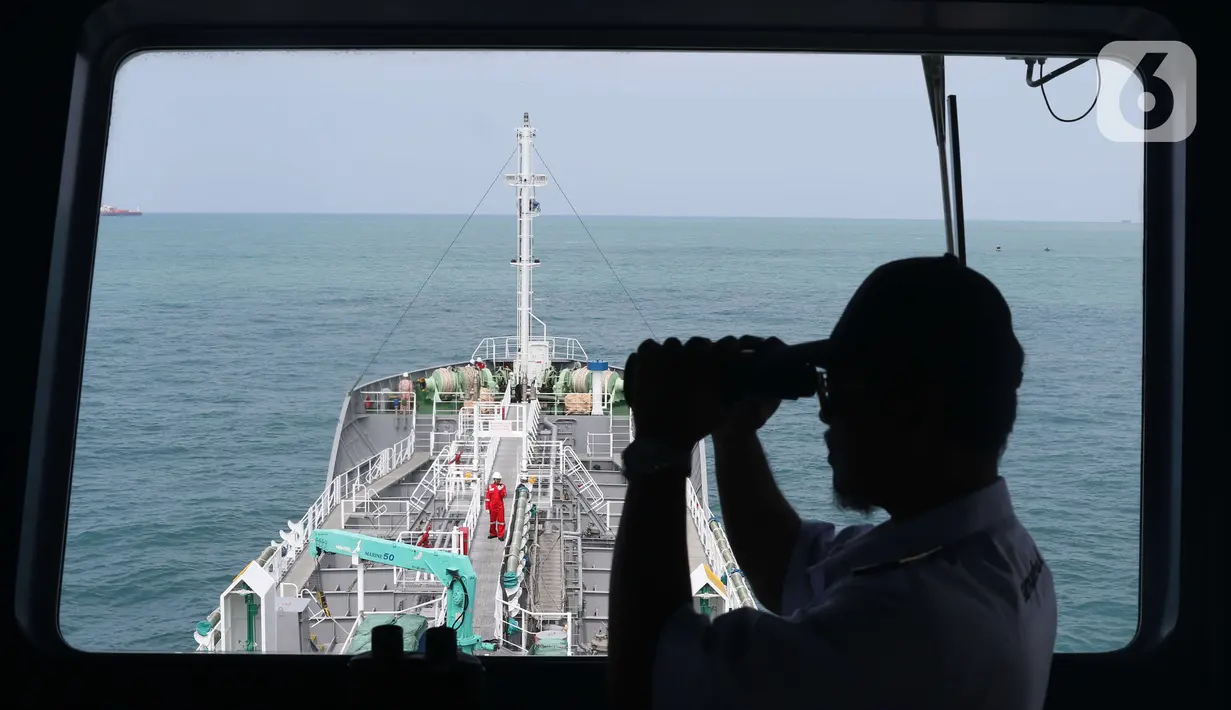 Petugas menggunakan teropong di atas kapal chemical tanker MT Sinar Morotai milik Samudera Indonesia di perairan Merak Banten, Kamis (5/12/2019). Armada berjenis chemical tanker ini bermuatan 4.500 KL untuk memenuhi asas cabotage dan transportasi logistik di Indonesia. (Liputan6.com/Angga Yuniar)