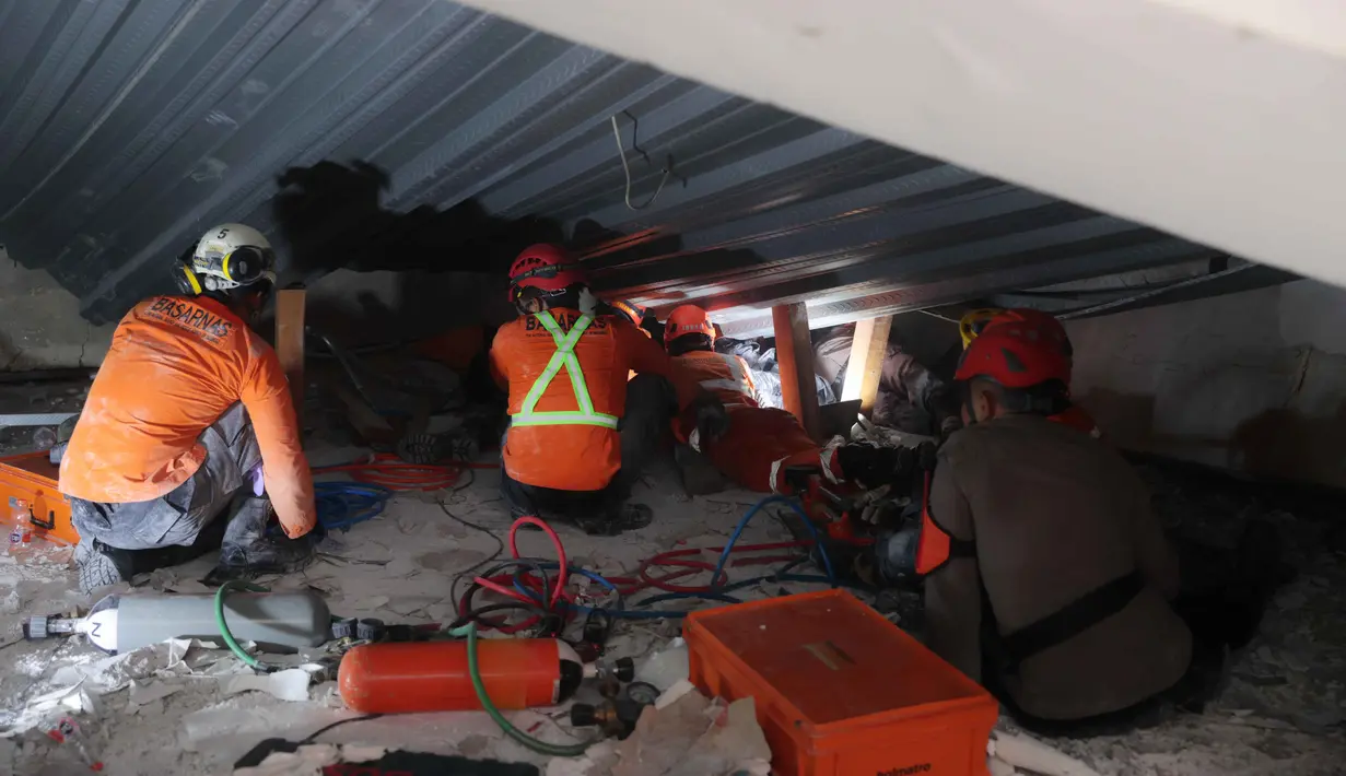 Sementara 11 lainnya berhasil dievakuasi dari bawah reruntuhan oleh tim SAR gabungan. Tampak dalam foto, tim penyelamat mencari korban selamat setelah bangunan yang sedang dibangun runtuh di sebuah pondok pesantren di Sidoarjo, Jawa Timur, Selasa 30 September 2025. (AP Photo/Trisnadi)