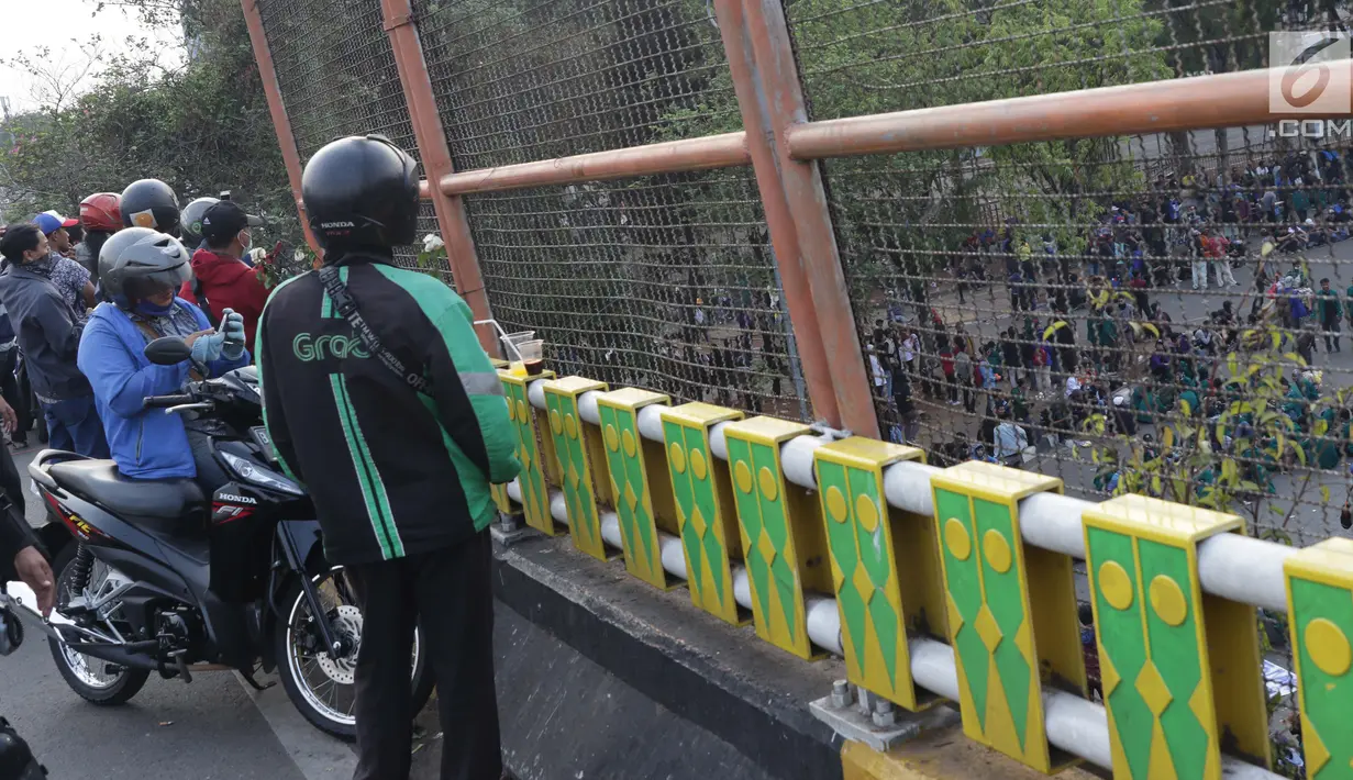 Warga menyaksikan aksi unjuk rasa yang dilakukan mahasiswa dari berbagai perguruan tinggi di sekitar Jembatan Layang Gerbang Pemuda, Jakarta, Selasa (1/10/2019). Mahasiswa dari berbagai perguruan tinggi kembali berunjuk rasa menolak beberapa RUU. (Liputan6.com/Helmi Fithriansyah)
