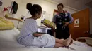 Petugas pembersih kaca berkostum Thor memberikan hadiah kepada seorang pasien anak di rumah sakit anak-anak di Guadalupe, Meksiko, 30 April 2019. Setelah bergelantungan dari jendela dan menjalankan tugas membersihkan kaca, para superhero masuk untuk menemui para pasien anak (REUTERS/Daniel Becerril)