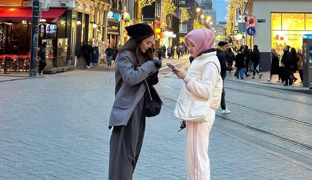 Mahalini tampil dengan blazer abu-abu oversize dipadukan celana panjang warna serasi. Putri Delina mengenakan padding vest putih dipadukan jaket dan celana putih dengan list pink yang diserasikan dengan kerudungnya.  [@putridelinaa]