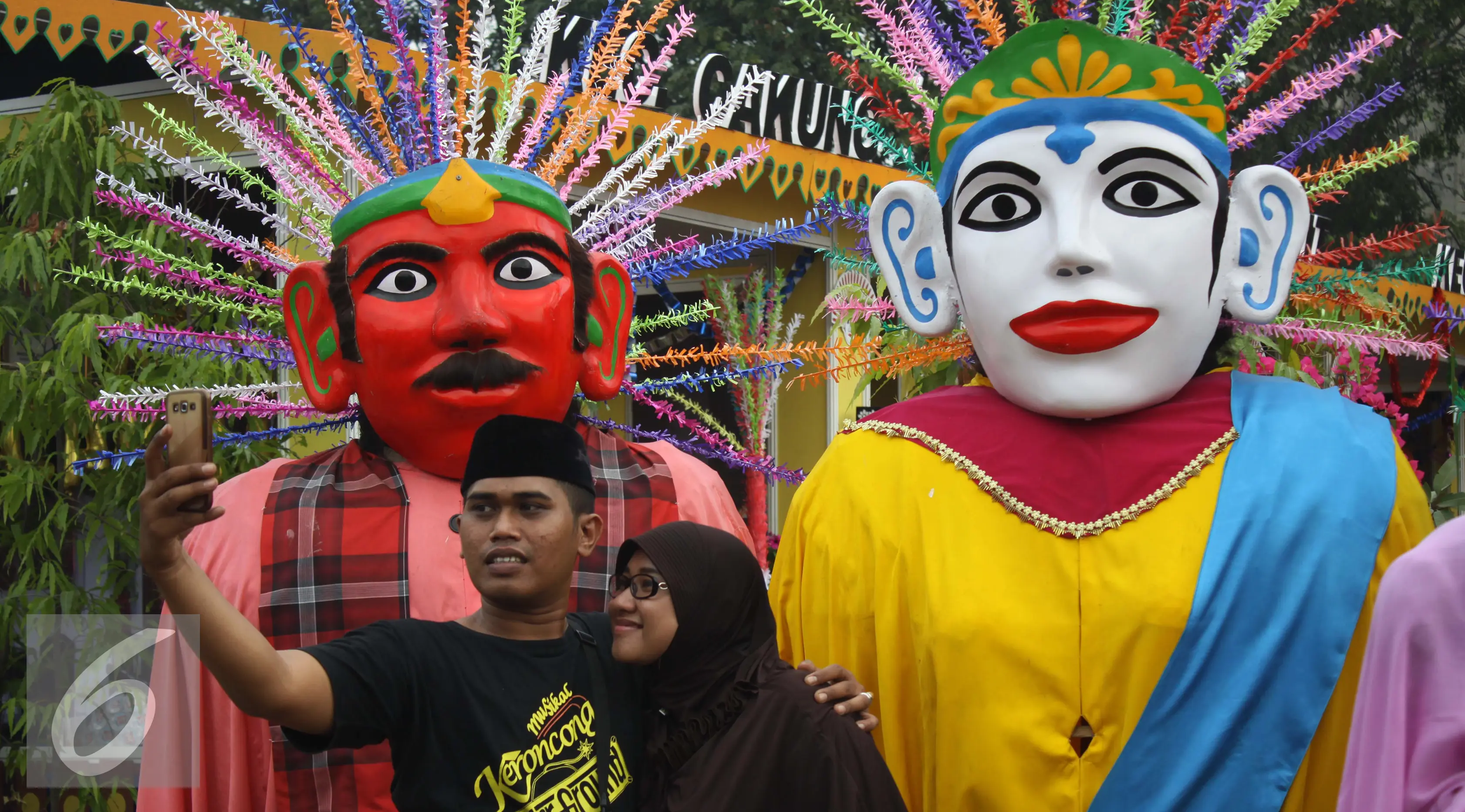 Pengunjung melakukan selfi didepan pajangan ondel-ondel dalam rangka Lebaran Betawi di Lapangan Banteng, Jakarta (22/08/15). Acara ini akan berlangsung pada tanggal 22-23 Agustus. (Liputan6.com/Gempur M Surya)