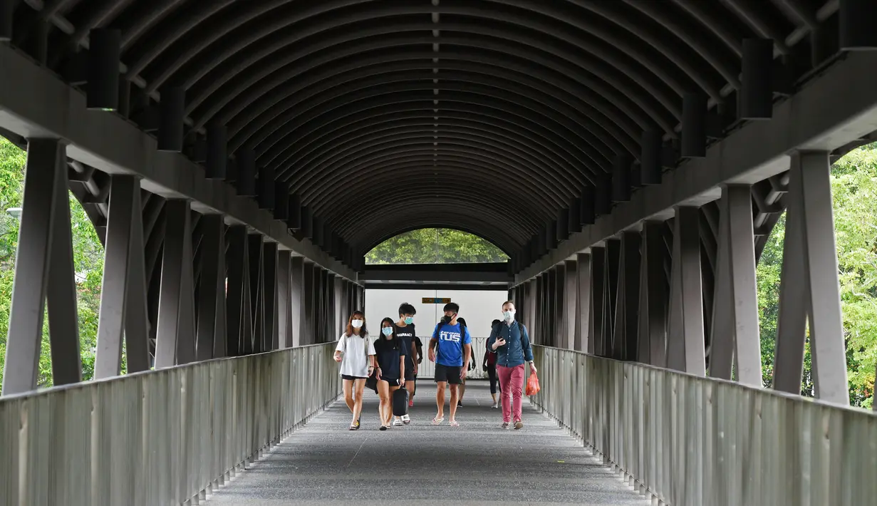 Para pejalan kaki tampak mengenakan masker saat melintasi sebuah jembatan penyeberangan orang di sepanjang Bukit Timah Road di Singapura pada 18 November 2020. (Xinhua/Then Chih Wey)